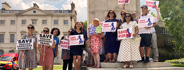 English language school staff hold placards in Westminster Square that read Save English Language Travel