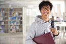 Asian_male_student_in_library_happy